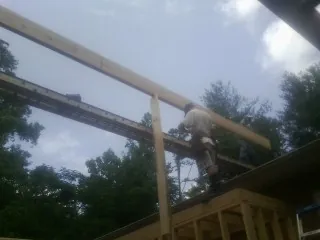 Carpenter setting a ridge beam over a new addition frame — Ice Dam Removal by Roofing Brothers in East Bethany