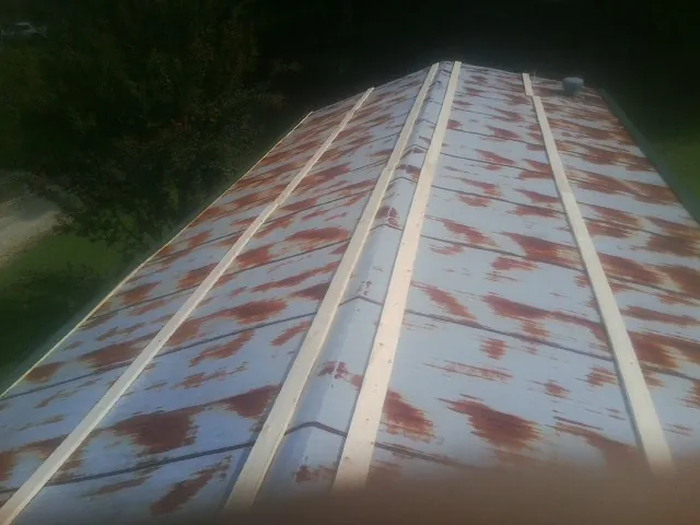 Rusted metal roof panels with new wood purlins before replacement — Storm Damage Roof Repair in East Bethany by Roofing Brothers