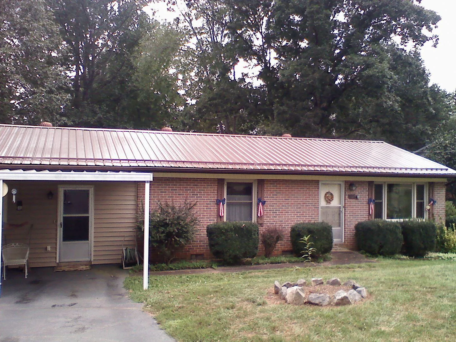 Bronze metal roof and carport on a brick ranch home — Roof Repair work by our crew in East Bethany