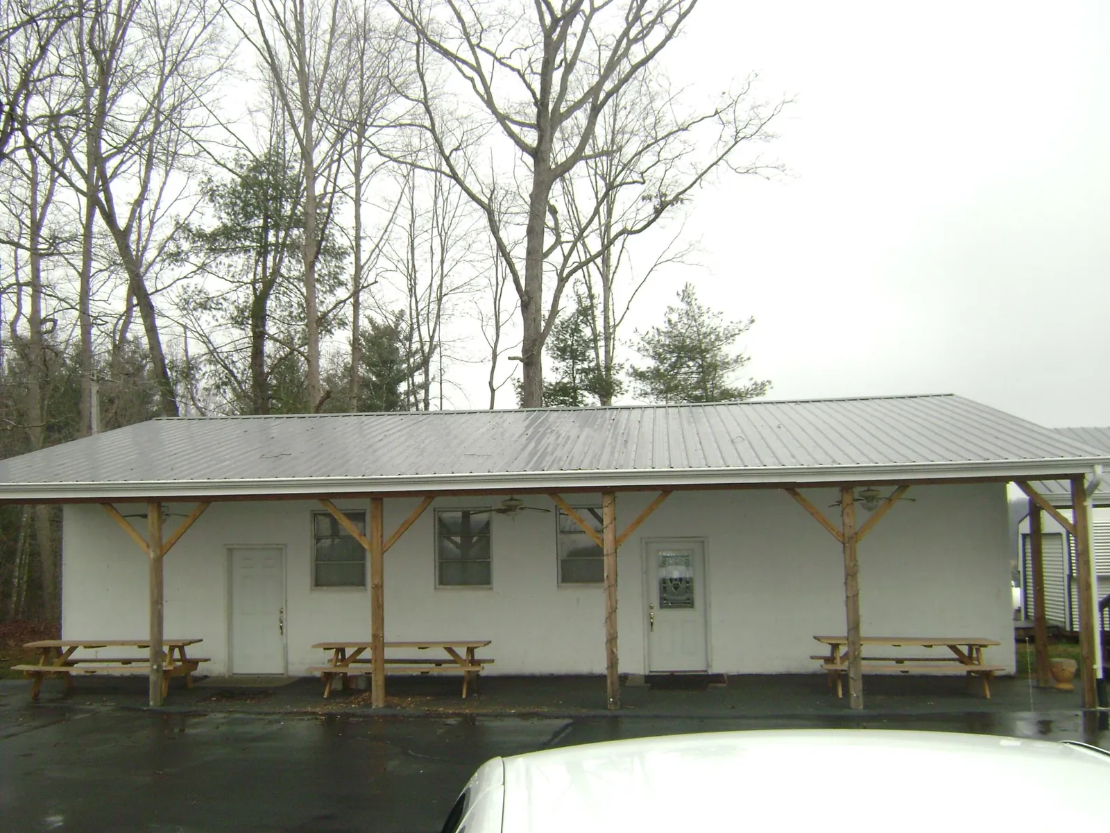 Gray metal roof over a block building with a timber post porch in East Bethany